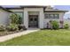 Charming home featuring a covered entry with double doors, manicured landscaping, and a well-maintained lawn at 2245 Pickard Ln, North Port, FL 34286