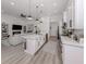 Bright, open-concept kitchen features an island, pendant lighting, stainless steel appliances, and seamless flow into the living area at 2245 Pickard Ln, North Port, FL 34286