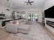 Spacious living room boasting a large sectional sofa, and seamless flow to the dining area and a view to the backyard at 2245 Pickard Ln, North Port, FL 34286