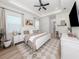 Bright main bedroom suite with tray ceiling, ceiling fan, and sitting area with a large patterned rug at 2245 Pickard Ln, North Port, FL 34286