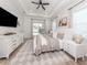 Bright main bedroom suite with dresser, ceiling fan, sitting area, and sliding glass door to the backyard at 2245 Pickard Ln, North Port, FL 34286