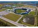 Wide aerial shot of a baseball stadium with green fields, parking lots, and a surrounding pond at 2355 Allsup Ter, North Port, FL 34286
