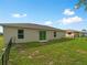 Well-maintained backyard featuring a grassy lawn, fenced area, and the home's exterior with sliding glass door at 2355 Allsup Ter, North Port, FL 34286