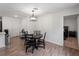 Dining area with sleek black table set, modern lighting, and wood-look flooring adjacent to the bedroom at 2355 Allsup Ter, North Port, FL 34286