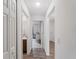 Bright hallway with wood-look floors leads to bathroom and bedrooms in this well-lit home at 2355 Allsup Ter, North Port, FL 34286
