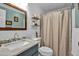 Neat bathroom with a vanity, toilet, and a shower featuring white tile and a neutral curtain at 239 Cutter Ct, North Port, FL 34287