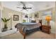 This bedroom features a ceiling fan, windows providing natural light, and a bed with a cozy grey blanket at 239 Cutter Ct, North Port, FL 34287