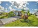 Inviting single-story home featuring a lush, green lawn, mature landscaping, and a concrete driveway at 239 Cutter Ct, North Port, FL 34287