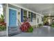 Charming covered porch features a vibrant blue front door and leafy decorative plants at 239 Cutter Ct, North Port, FL 34287