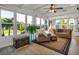 Bright, sunlit living room with wood floors, ceiling fan, neutral furniture, and outdoor views at 239 Cutter Ct, North Port, FL 34287