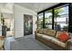 A bright sun room with floor to ceiling glass windows and a striped couch at 239 Cutter Ct, North Port, FL 34287