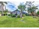 Expansive backyard boasts lush greenery, tropical palms, flowering shrubs, and screened pool enclosure at 2445 Apache St, Sarasota, FL 34231