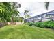 Well-maintained backyard featuring green grass, a fenced perimeter, and a screened-in lanai at 2445 Apache St, Sarasota, FL 34231