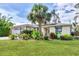 Charming one-story home with a lush green lawn and mature landscaping, including a beautiful palm tree at 2445 Apache St, Sarasota, FL 34231