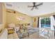 Spacious living room featuring neutral tones, tile floors, ceiling fan, and access to the pool at 2445 Apache St, Sarasota, FL 34231