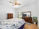 Cozy bedroom with ceiling fan, wood floors, bright light, and classic furnishings at 24536 Buckingham Way, Port Charlotte, FL 33980