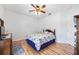 Traditional bedroom with hardwood floors, a ceiling fan, and neutral decor at 24536 Buckingham Way, Port Charlotte, FL 33980