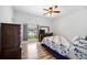 Comfortable bedroom featuring hardwood floors, a large window, and a ceiling fan at 24536 Buckingham Way, Port Charlotte, FL 33980
