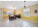 Elegant dining room with natural light, tile flooring, and a chandelier lighting at 24536 Buckingham Way, Port Charlotte, FL 33980
