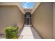 Inviting front entrance with stone landscaping and a modern white metal entry door at 24536 Buckingham Way, Port Charlotte, FL 33980