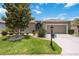 Charming home featuring a well-manicured lawn, mature trees, and a two-car garage on a sunny day at 24536 Buckingham Way, Port Charlotte, FL 33980