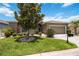 Beautiful home featuring well-manicured lawn, shrubs, and a two-car garage on a sunny day at 24536 Buckingham Way, Port Charlotte, FL 33980