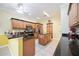 Well-equipped kitchen with an island, wooden cabinetry, granite countertops, and tile floors at 24536 Buckingham Way, Port Charlotte, FL 33980