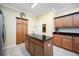 A kitchen showcasing an island with granite counters, custom cabinets, and stainless steel refrigerator at 24536 Buckingham Way, Port Charlotte, FL 33980