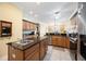 Traditional kitchen with granite counters, stainless steel appliances, island sink, and tile flooring at 24536 Buckingham Way, Port Charlotte, FL 33980