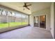 Enclosed lanai with a ceiling fan and views of the backyard at 24536 Buckingham Way, Port Charlotte, FL 33980