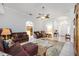 Inviting living room with tile floors, archways, a ceiling fan, and comfortable leather furniture at 24536 Buckingham Way, Port Charlotte, FL 33980