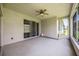 Screened-in patio with ceiling fan and access to the backyard through sliding glass doors at 24536 Buckingham Way, Port Charlotte, FL 33980