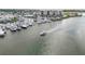 Aerial showcases a boat cruising near waterfront condos and a marina at 250 Santa Maria St # 314, Venice, FL 34285