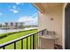 Balcony with seating area overlooking a green lawn, canal and surrounding buildings on a sunny day at 250 Santa Maria St # 314, Venice, FL 34285