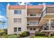 A three-story condo building with a red tile roof and black iron railings, surrounded by lush landscaping at 250 Santa Maria St # 314, Venice, FL 34285