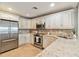Bright kitchen with white cabinets, stainless appliances and tan granite countertops at 250 Santa Maria St # 314, Venice, FL 34285