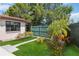 Manicured backyard with lush lawn, vibrant plants, and privacy fence at 2555 Yucca Rd, Venice, FL 34293