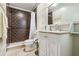 Stylish bathroom with dark brown tiled shower, toilet, and white vanity with elegant mirror at 2555 Yucca Rd, Venice, FL 34293
