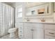 Bright bathroom with a double sink vanity, decorative mirror, and shower-tub combo at 2555 Yucca Rd, Venice, FL 34293