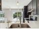 Modern kitchen with stainless appliances, dark cabinets, quartz countertops and pool access at 2555 Yucca Rd, Venice, FL 34293