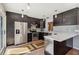 Modern kitchen with stainless appliances, dark cabinets, and quartz countertops at 2555 Yucca Rd, Venice, FL 34293