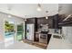 Modern kitchen with stainless appliances, dark cabinets, quartz countertops and pool access at 2555 Yucca Rd, Venice, FL 34293