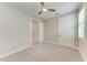 Bedroom with carpet, a ceiling fan, a large window, and two doors at 257 Teramo Way, Nokomis, FL 34275