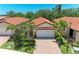 Charming villa featuring a tile roof, two-car garage, brick driveway and tropical landscaping at 257 Teramo Way, Nokomis, FL 34275