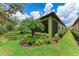Side view of home with tropical landscaping, screened-in patio, and well-maintained lawn at 257 Teramo Way, Nokomis, FL 34275