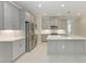 Bright kitchen with gray cabinets, a stainless steel refrigerator, and ample counter space at 257 Teramo Way, Nokomis, FL 34275