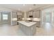 Modern kitchen with gray cabinetry, stainless steel appliances, and a quartz island at 257 Teramo Way, Nokomis, FL 34275