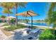 Lakeside lounge area with umbrella, chairs and views of the community lake at 257 Teramo Way, Nokomis, FL 34275