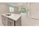 Open living area featuring tile floors, a modern kitchen island, and natural light at 257 Teramo Way, Nokomis, FL 34275