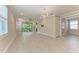 Spacious living area with neutral walls, tile floors, and sliding glass doors leading to the outside at 257 Teramo Way, Nokomis, FL 34275